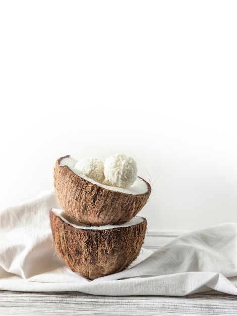 Deux moitiés de bonbons à la noix de coco et à la noix de coco sur une table en bois