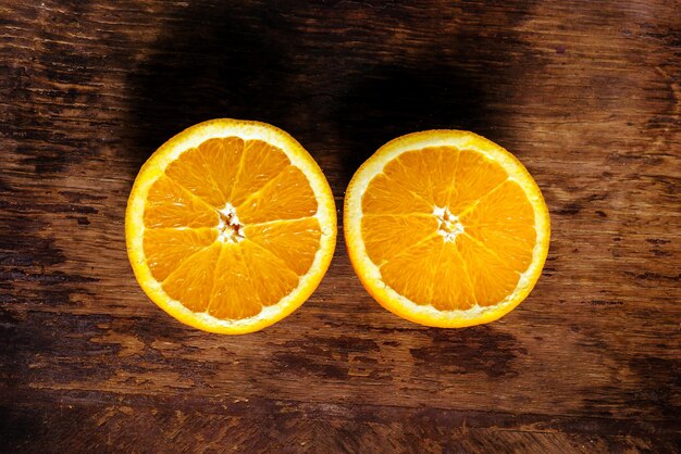 Deux moitiés d'une orange sur un fond de bois