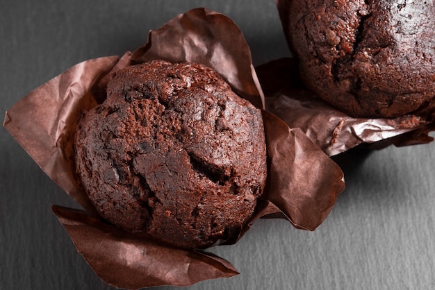 Deux muffins au chocolat sur une table grise