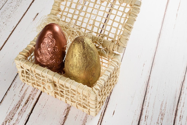 Deux oeufs de Pâques peints avec de la peinture comestible, sur un panier de paille de maïs (avec copie espace).