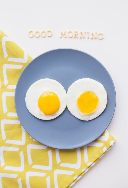 Photo deux oeufs pochés sur une assiette avec good morning