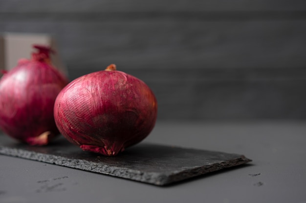 Deux oignons rouges non pelés sur fond noir