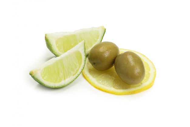 Deux olives et morceau de citron et de citron vert isolé sur blanc