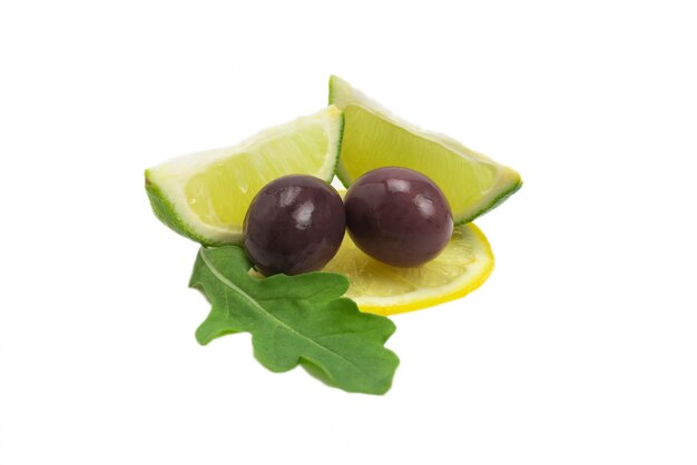 Deux olives, morceau de citron et feuilles de roquette isolés