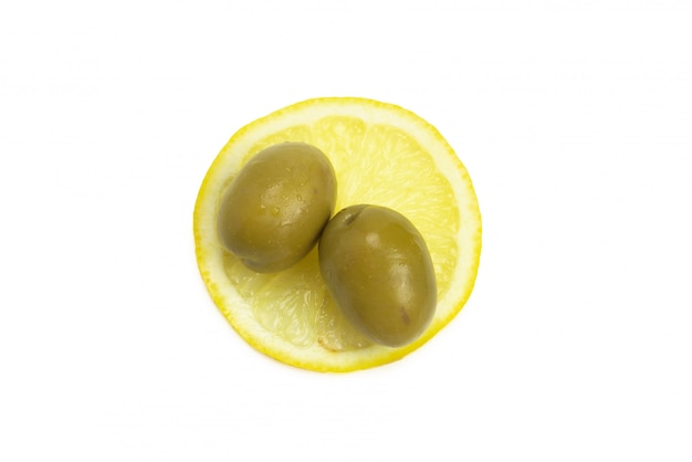 Deux olives, morceau de citron et feuilles de roquette isolés