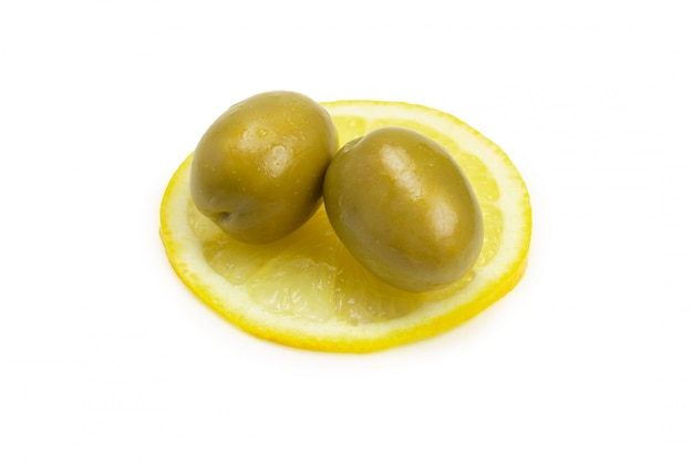 Deux olives et morceau de citron isolé sur blanc