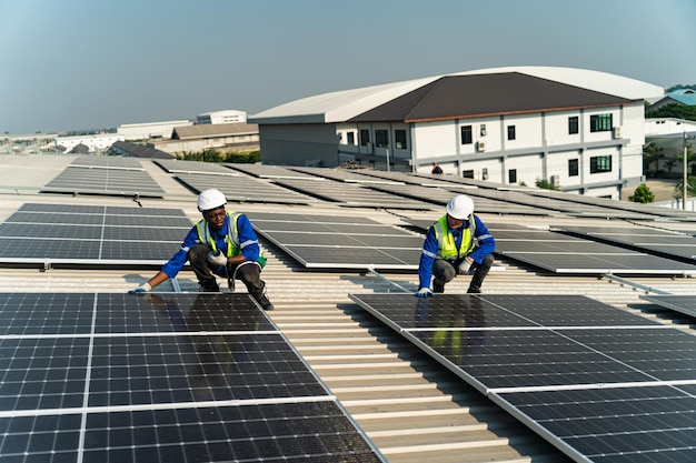 Deux ouvriers installent des panneaux solaires sur un toit.