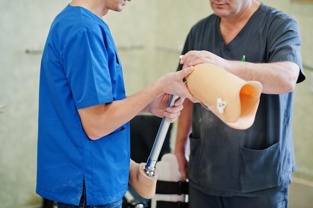 Deux ouvriers prothésistes avec jambe prothétique travaillant en laboratoire