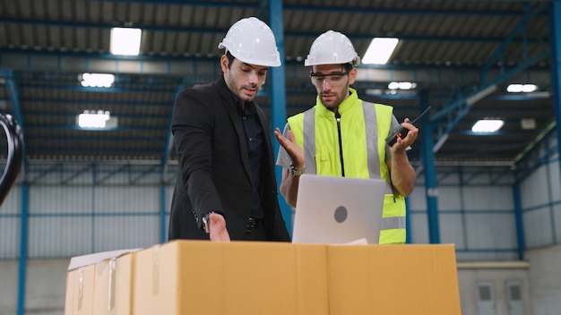 Deux Ouvriers D'usine Travaillant Et Discutant Du Plan De Fabrication Dans L'usine. Concept D'industrie Et D'ingénierie.