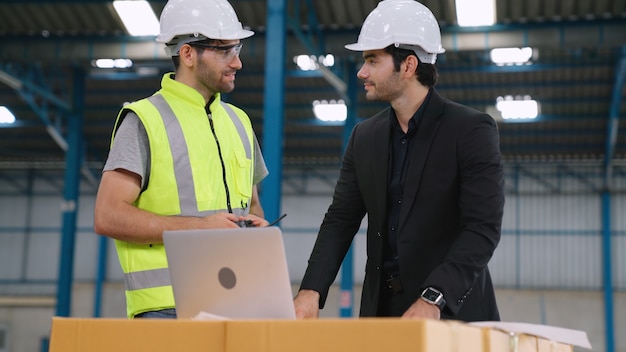 Deux ouvriers d'usine travaillant et discutant du plan de fabrication dans l'usine . Concept d'industrie et d'ingénierie.