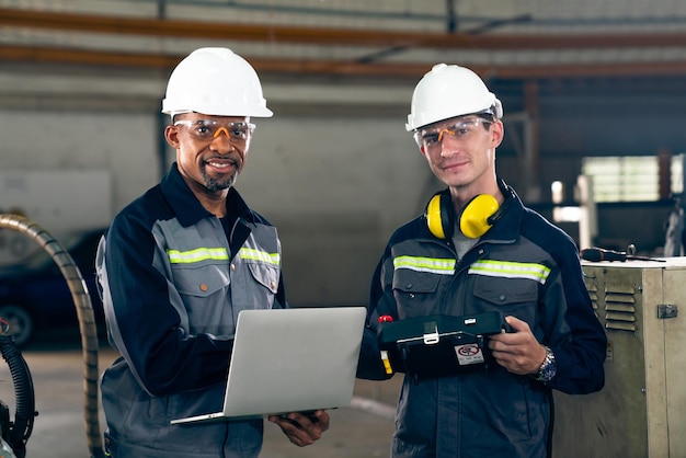 Deux ouvriers d'usine utilisant un équipement de machine adepte dans un atelier