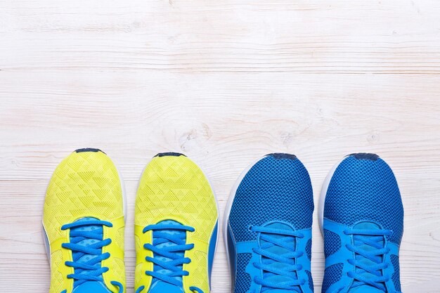 Deux paires de chaussures de sport bleu et jaune sur fond blanc