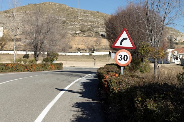 Deux panneaux de signalisation pour les virages dangereux et limitation de vitesse à 30