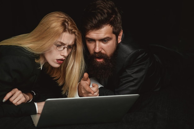 Deux partenaires commerciaux travaillant ensemble avec un ordinateur portable Couple homme et fille surfant sur Internet dans un ordinateur portable