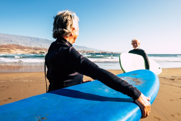 Deux personnes âgées et matures profitant de leurs vacances à l'extérieur à la plage s'amusant ensemble