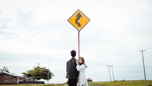 Deux personnes debout sous un panneau de signalisation qui dit " je vais à droite ".