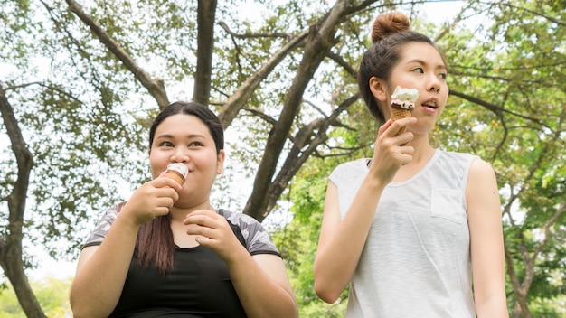 deux personnes grosse et mignonne fille mangent de la crème glacée avec un sentiment délicieux