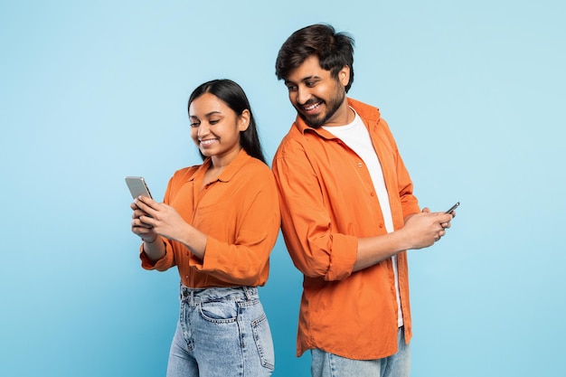 Deux personnes, un homme et une femme, utilisant des smartphones en bleu.