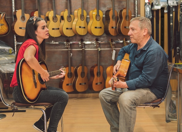 Deux personnes jouant de la guitare dans un magasin de guitare classique