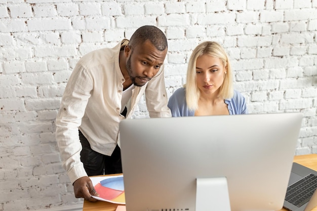 Deux personnes regardant un écran d'ordinateur qui dit "il est temps de l'obtenir"