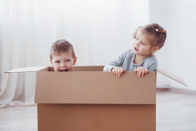 Deux un petit garçon et une fille viennent d’emménager dans une nouvelle maison. Concept photo .. Les enfants s'amusent.