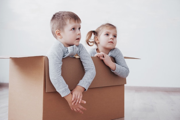 Deux un petit garçon et une fille viennent d’emménager dans une nouvelle maison. Concept photo .. Les enfants s'amusent.