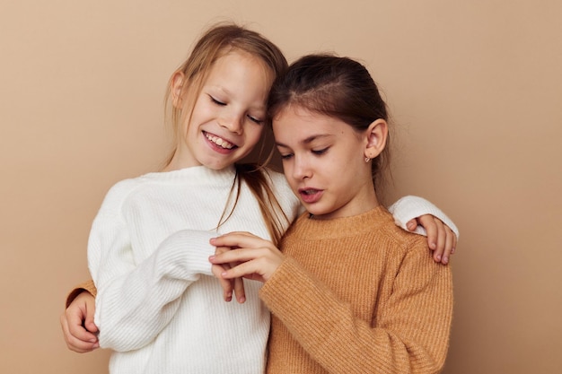 Deux petites copines drôles serrant ensemble fond isolé