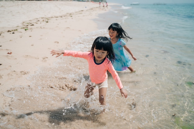 Deux petites filles asiatiques jouant sur la plage