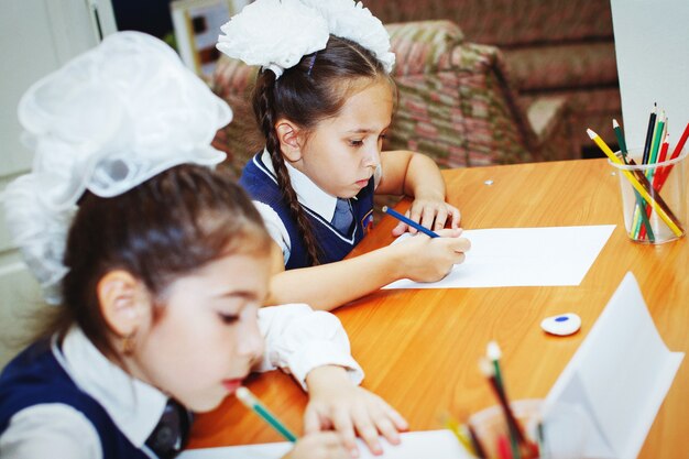 Deux petites filles concentrées dessinant sur papier à table