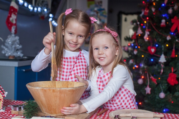 Deux petites filles font des biscuits de pain d'épice pour Noël