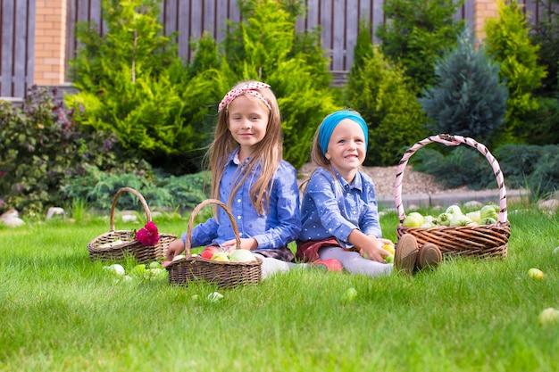 Deux petites filles heureuses avec une grande récolte de tomates d'automne