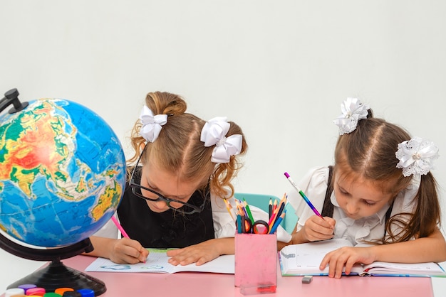 deux petites filles heureuses peignant en classe