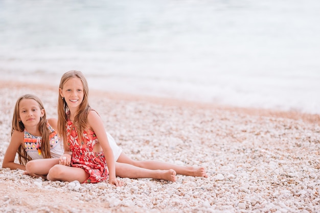 Deux petites filles heureuses s'amusent beaucoup sur une plage tropicale en jouant ensemble