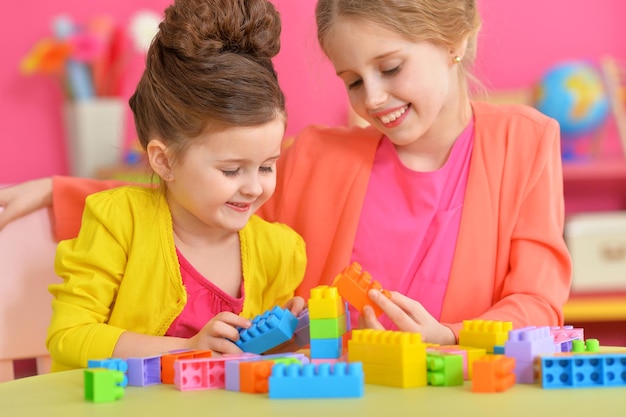 Deux petites filles jouant avec des blocs en plastique colorés