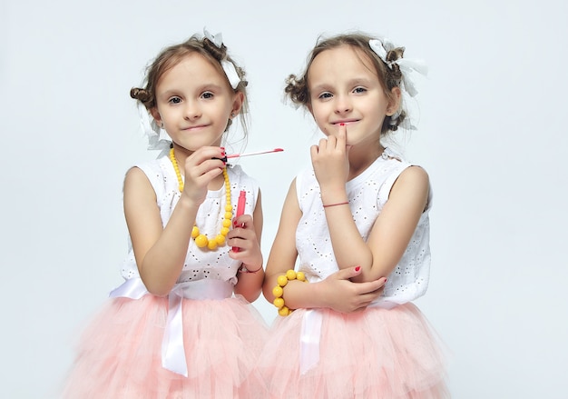 Deux petites filles jouant avec le maquillage de leur mère