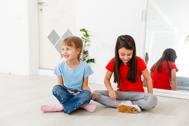 deux petites filles jouent avec un hamster