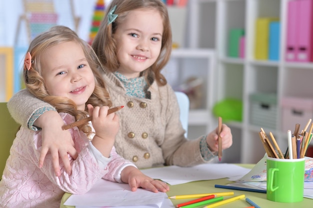 Deux petites filles mignonnes dessinant avec des crayons