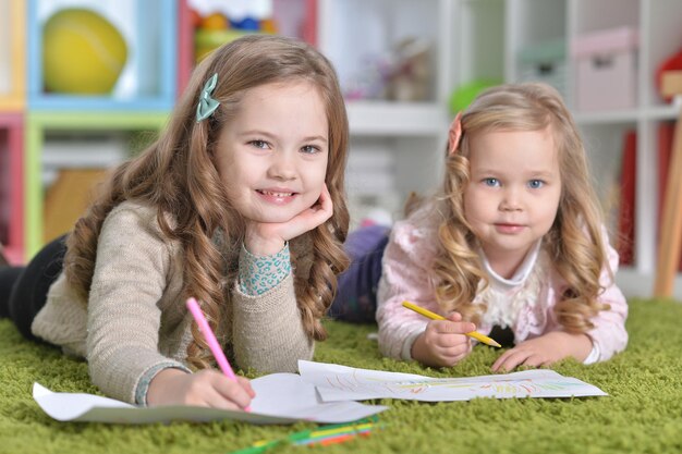 Deux petites filles mignonnes dessinant avec des crayons