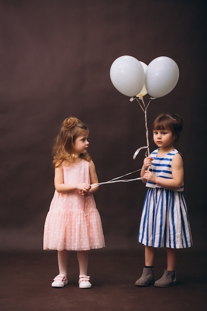 Deux petites filles modèles studio avec des ballons