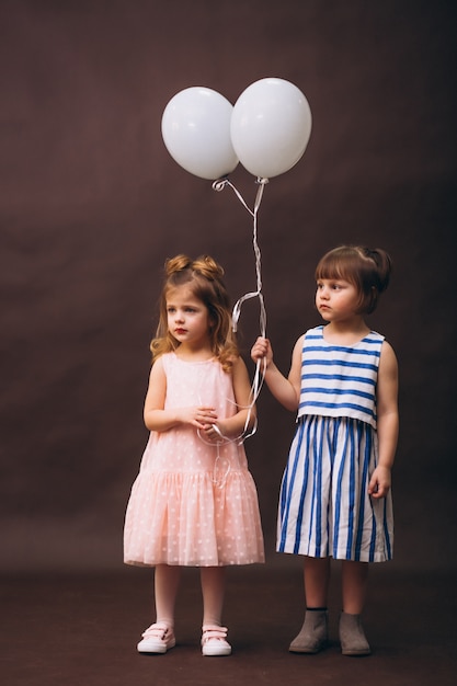 Deux petites filles modèles studio avec des ballons