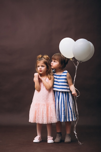 Deux petites filles modèles studio avec des ballons