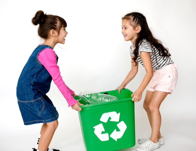 Deux petites filles en mouvement une boîte de recyclage