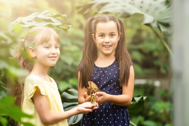 deux petites filles avec des papillons dans une serre