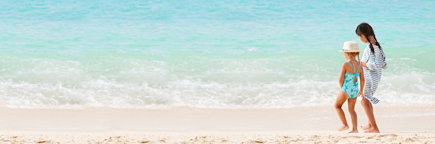 Deux petites filles sur la plage de sable par derrière