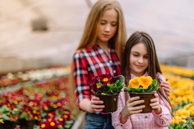 Deux petites filles regardent un pot de fleurs dans un centre de fleurs