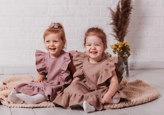 Deux petites filles en robes magnifiques au studio avec des fleurs