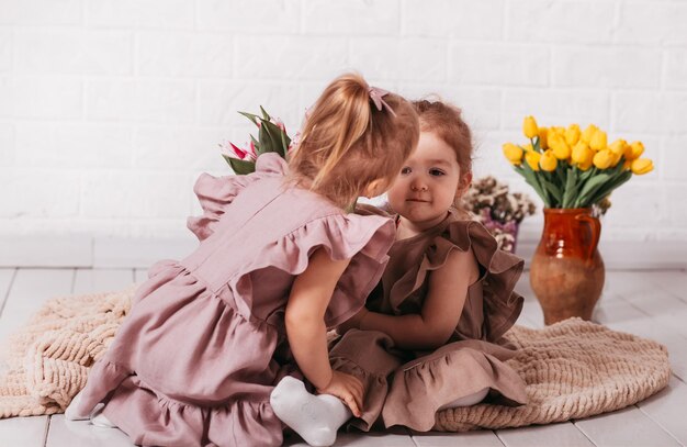 Deux petites filles en robes magnifiques au studio avec des fleurs