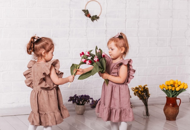 Deux petites filles en robes magnifiques au studio avec des fleurs