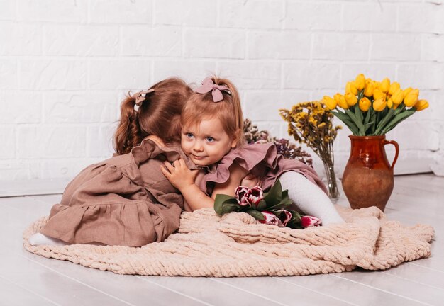 Deux petites filles en robes magnifiques au studio avec des fleurs