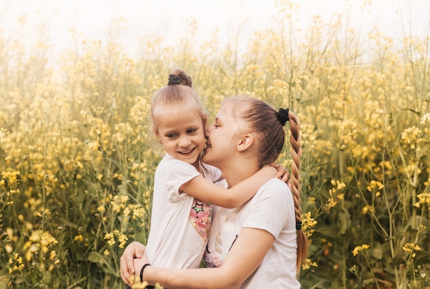 Deux petites sœurs filles se blottissent dans la nature en été